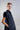 Vista lateral de vestido midi de popelín con mangas de frunce estructurado, con caída ligera y estructura que aporta volumen sutil al diseño.