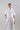 Front view of a short-sleeve cotton bolero with small collar, front button closure and functional chest pockets.